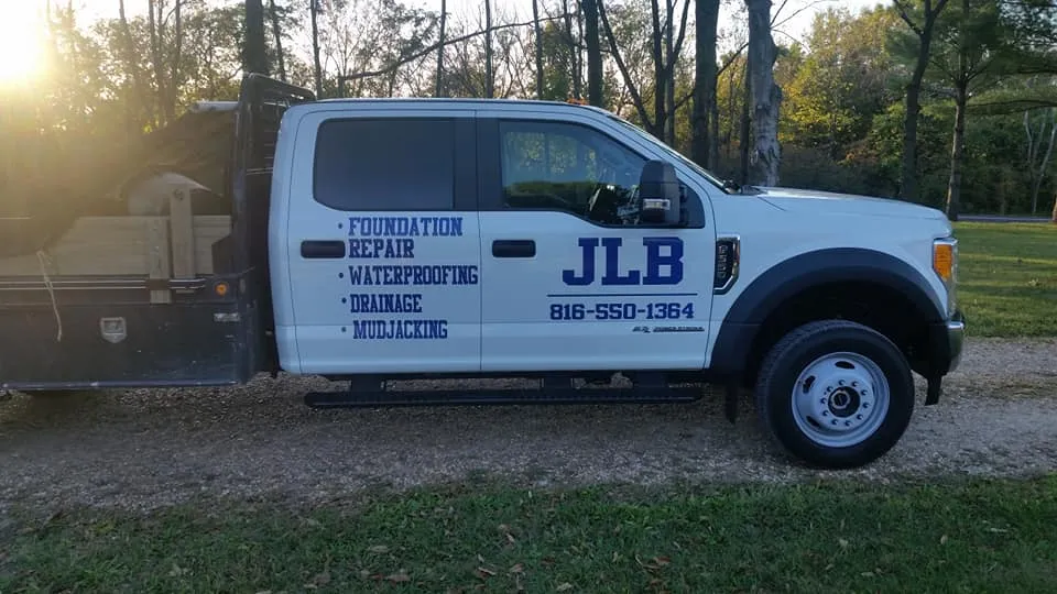 Side view of JLB branded foundation repair truck on job in Des Moines